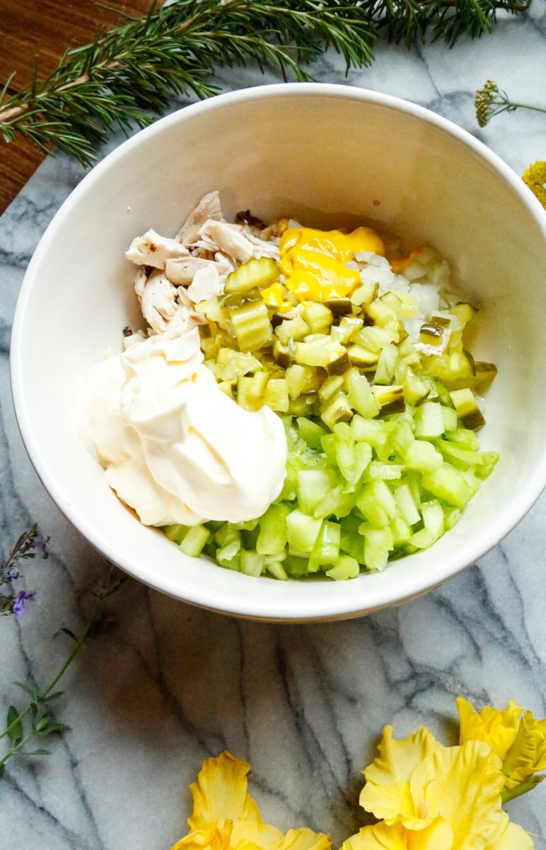 Mayonnaise added to rotisserie chicken, celery, dill pickles, and onion for dill pickle chicken salad.