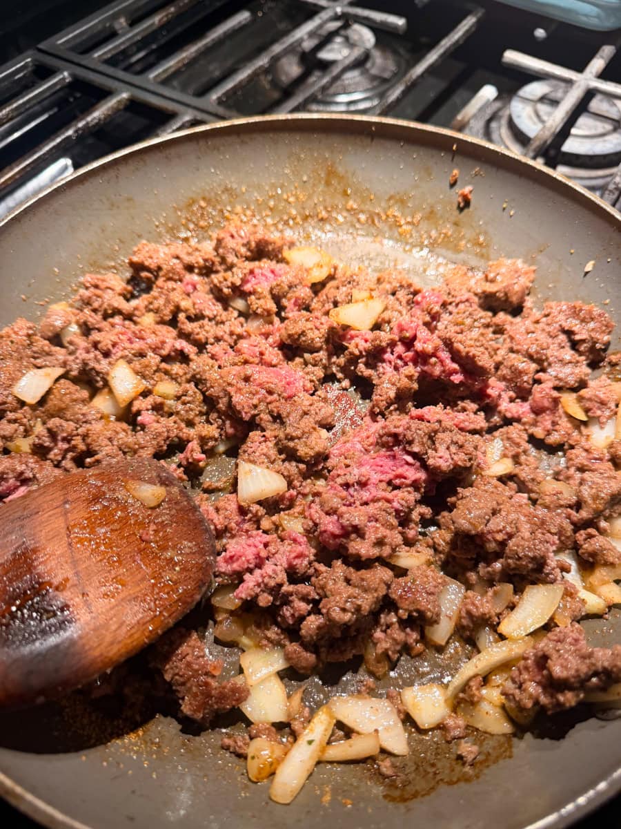 Simmer the ground beef and yellow onion and chopped garlic together in a pan