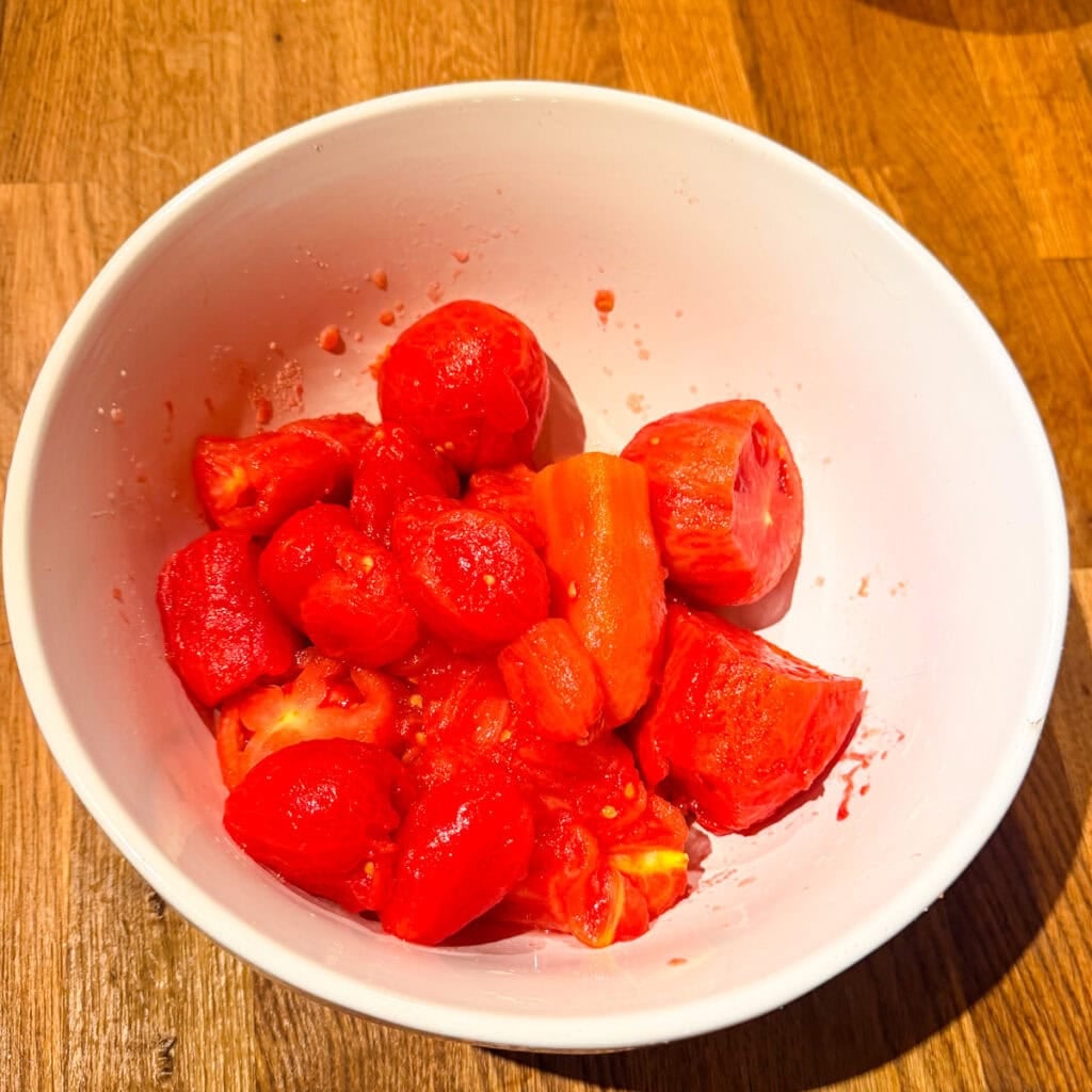 Peeled and chopped blanched tomatoes in a white bowl.
