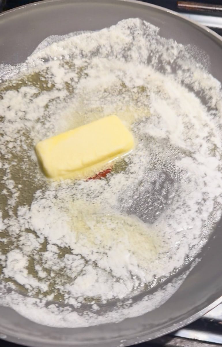 Melting unsalted butter in a large skillet over low heat to make homemade Halloween Rice Krispies Treats.