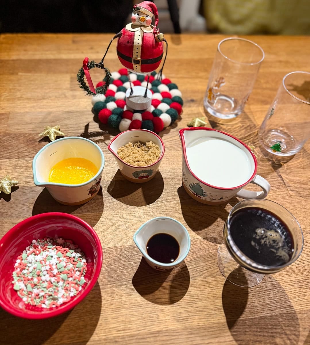 Ingredients for homemade sugar cookie latte, including espresso, milk, butter, brown sugar, vanilla, and Christmas sprinkles.